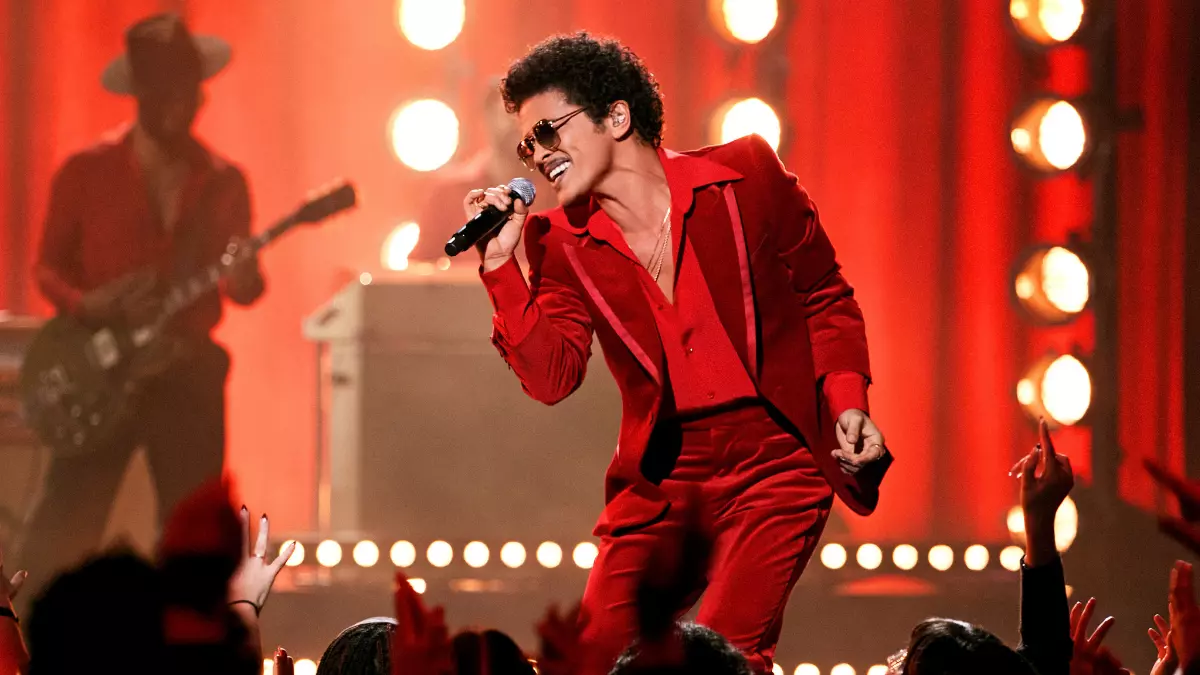 Bruno Mars on stage in a red suit, dramatic red lighting