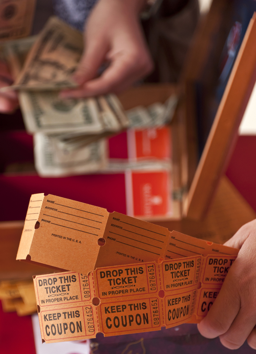 Oversized golden concert ticket sitting on a pile of gold coins, red background — symbolising ticket-price inflation